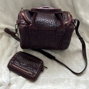 Alexander Wang pebbled maroon bag with gold hardware and matching wallet.